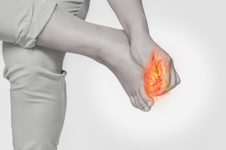 Woman foot nail pain.Concept photo with Color Enhanced pale skin with Fire indicating location of the pain.